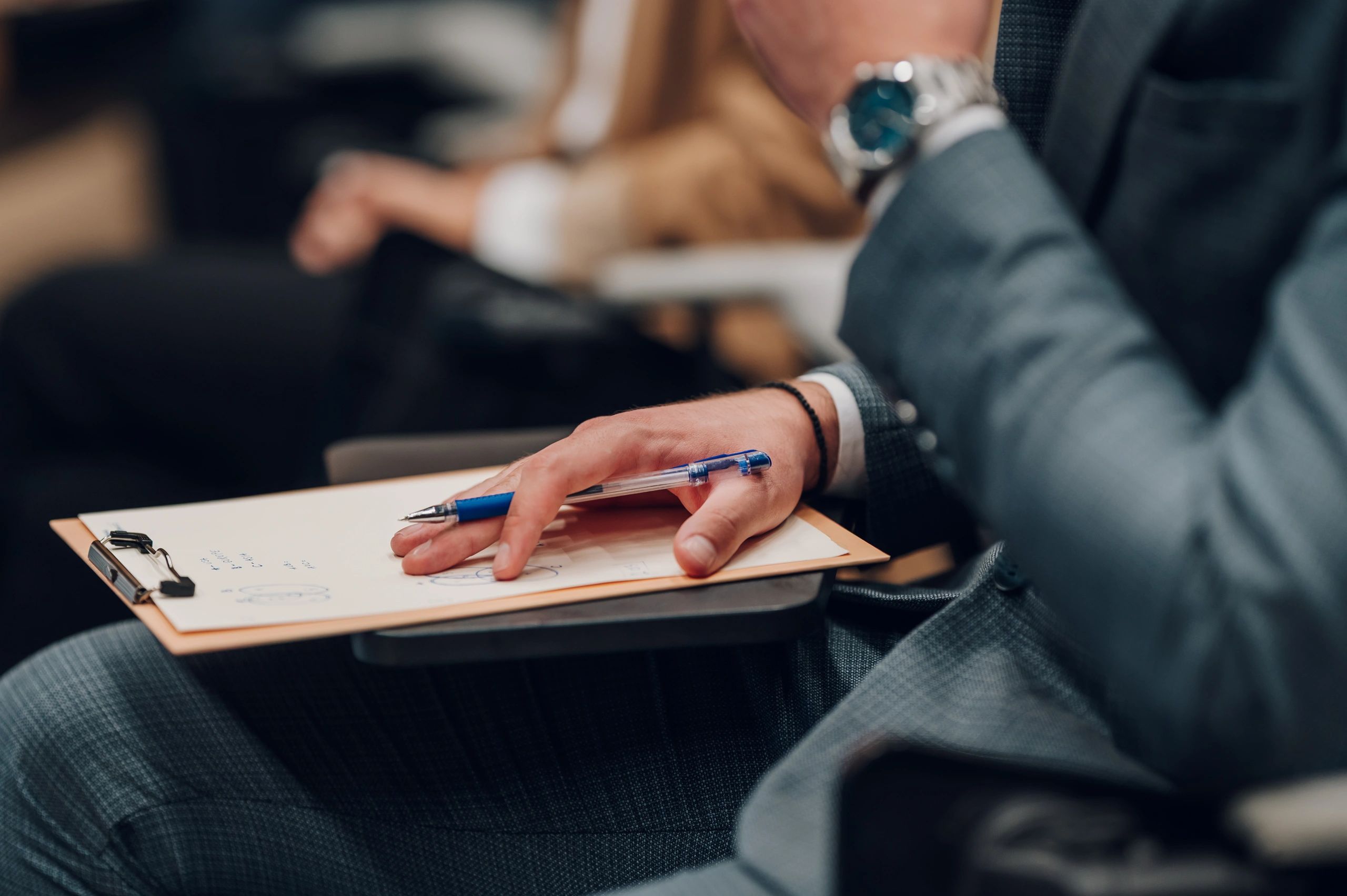 Hands writing in a journal with a pen